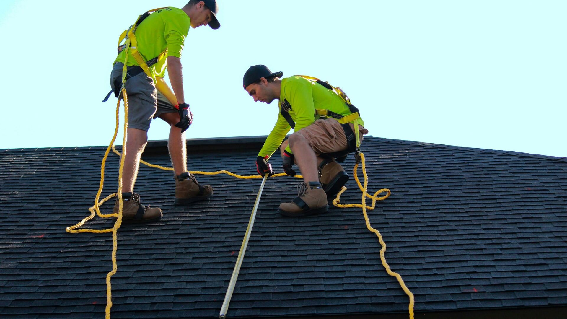 Roofers setting shingles on a residential roof